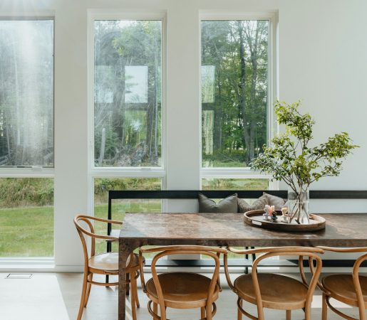 a dining room table with chairs and a vase of flowers